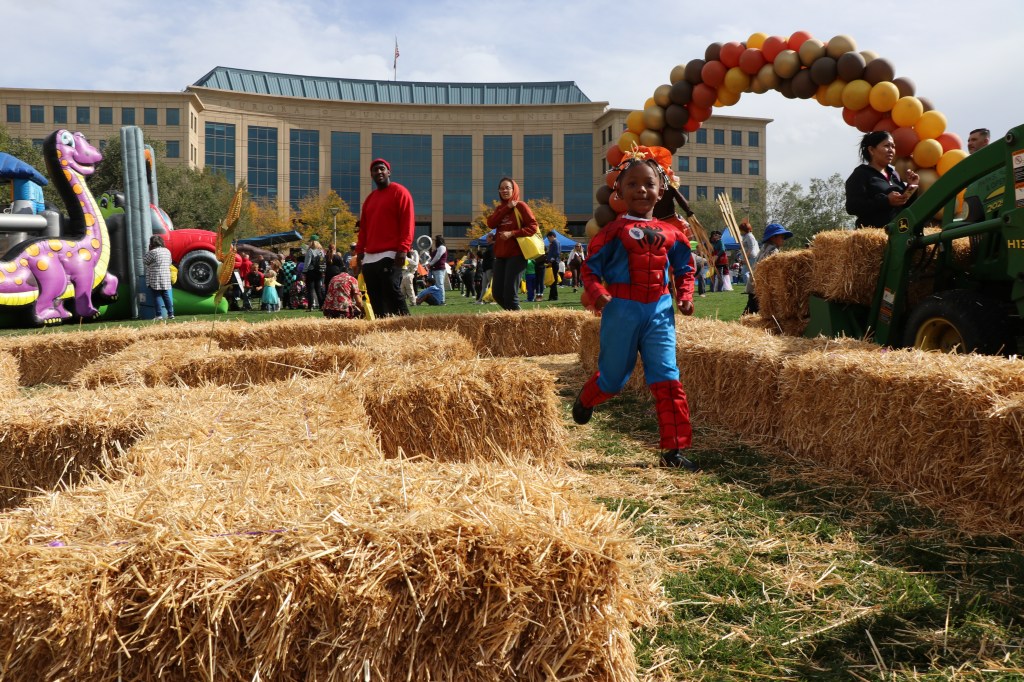 A child runs through a hay maze