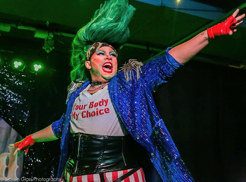 A drag qrtist with a green mohawk