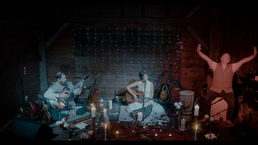 three musicians sitting and performing a casual concert
