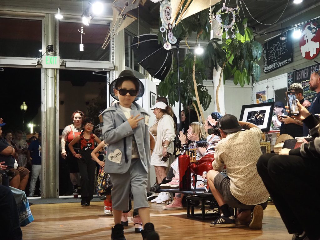 A boy in a blue suit and sunglasses