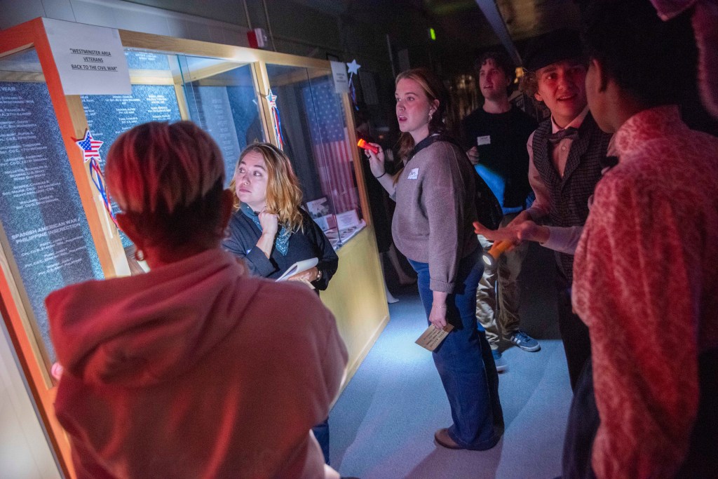 People with flashlights in the DeSpan Schoolhouse.