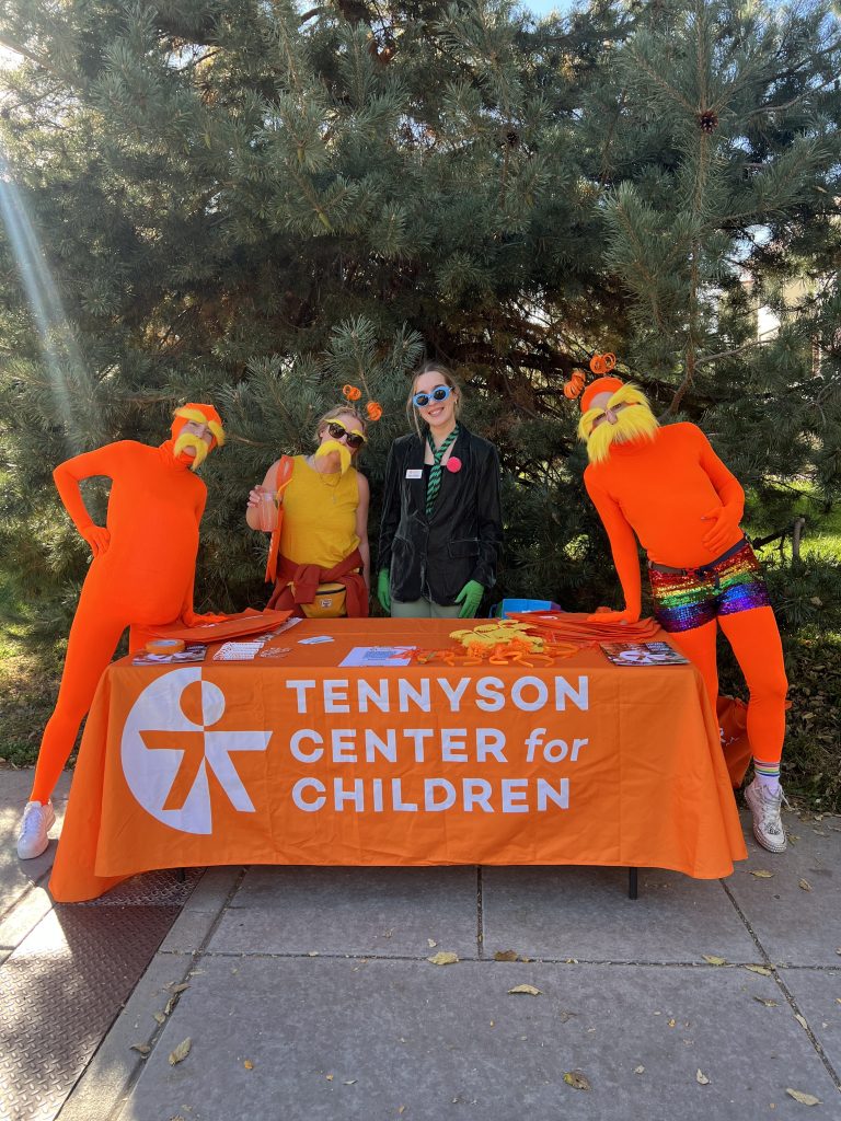 People dressed as loraxes behind a table