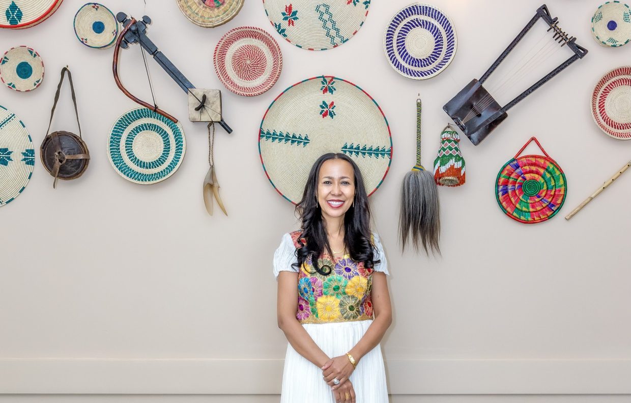A women in front of a wall of Ethiopian tools
