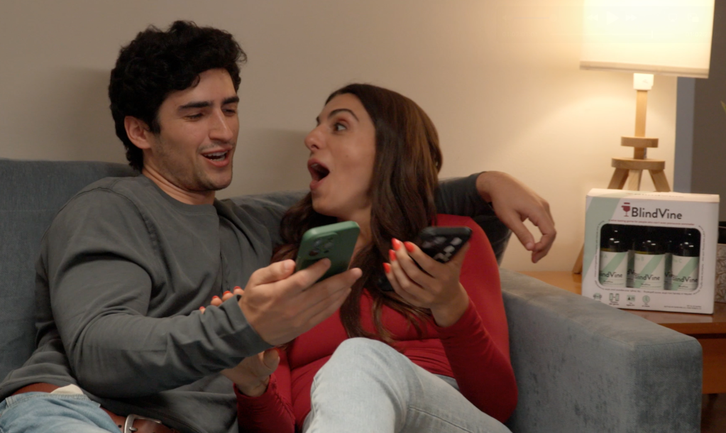 a couple on a couch looking at their phone