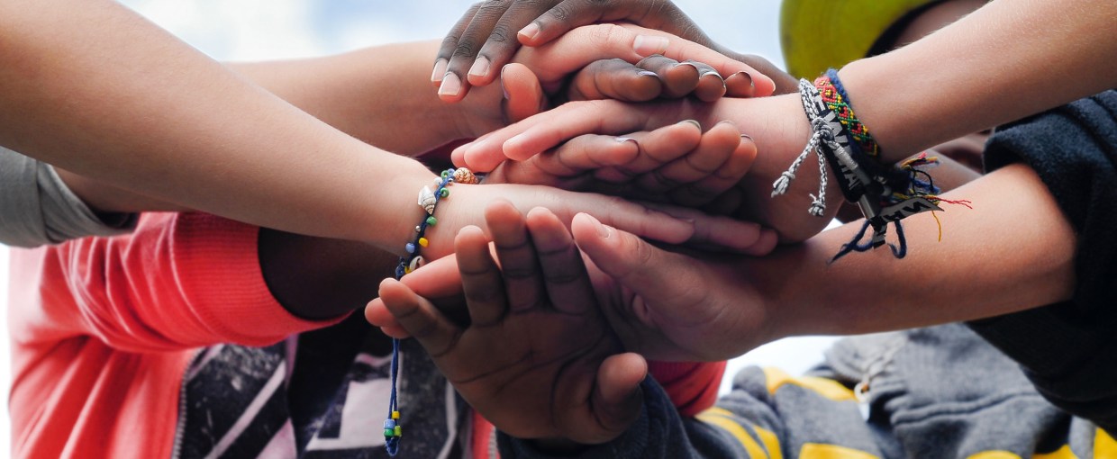multiracial teenagers joining hands