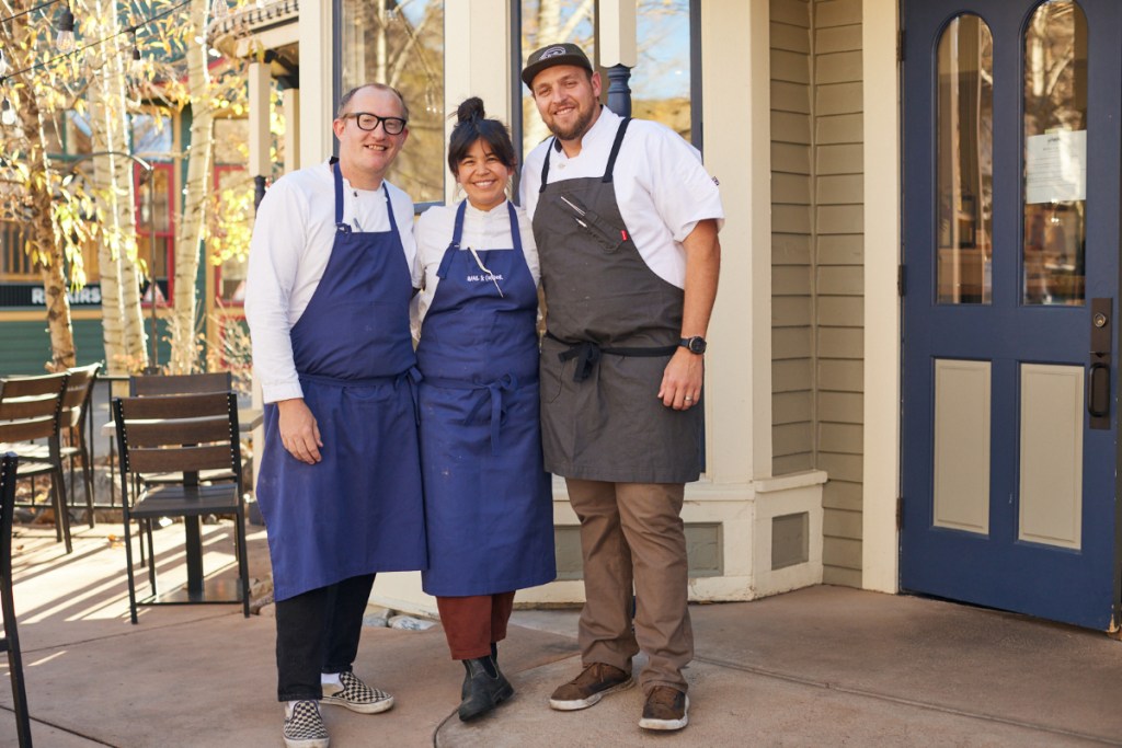 three people in aprons posing
