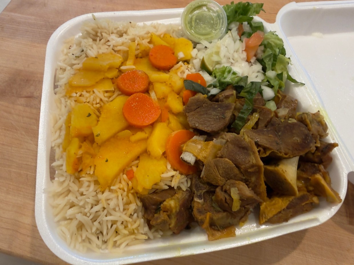 a plate of goat meat and rice