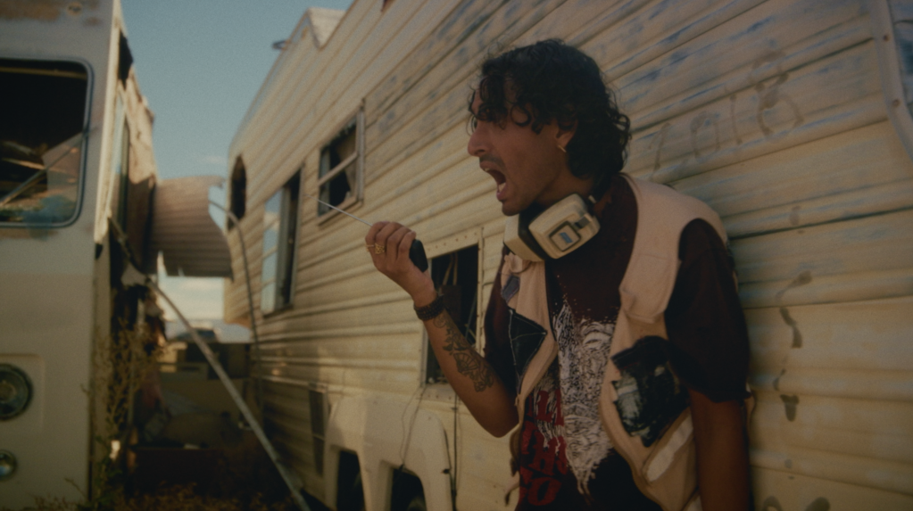 man holding a walkie talkie leaning on a trailer