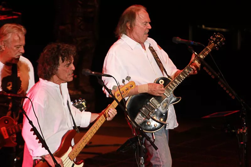 two men in white shirts playing guitar
