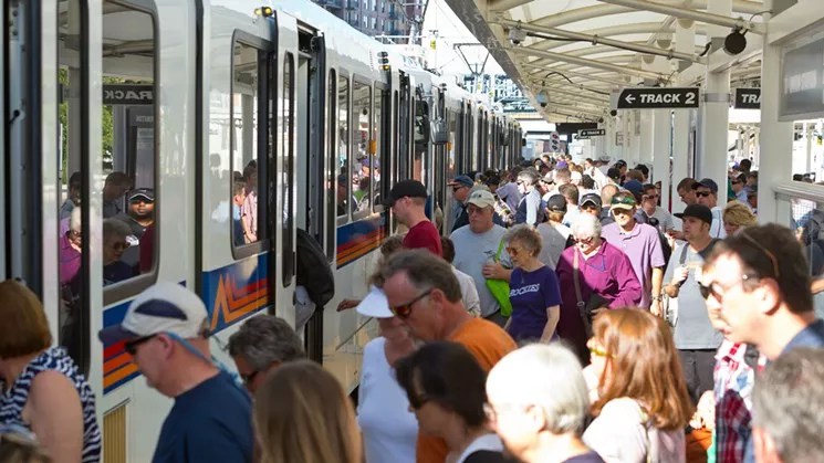 People line up to get on a train.