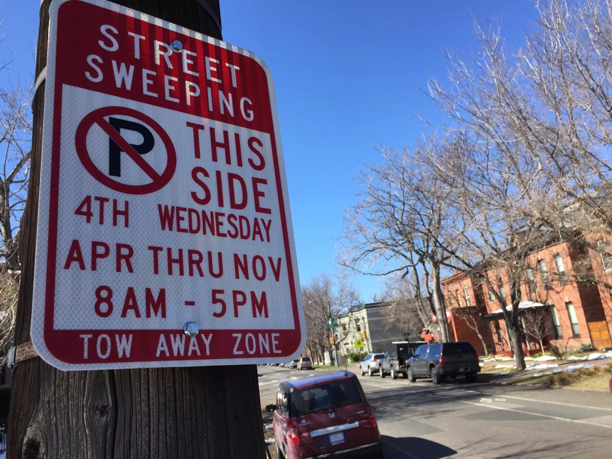 A street sweeping sign in downtown Denver