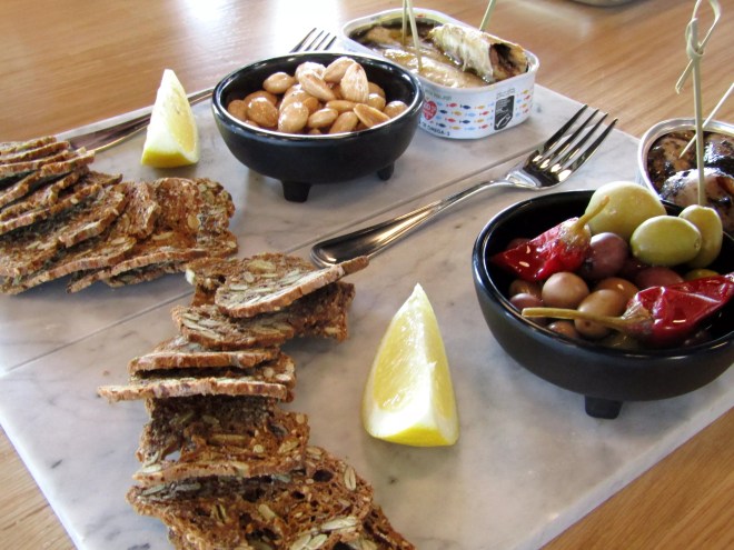 A Charcuterie spread of olives, nuts and crackers.