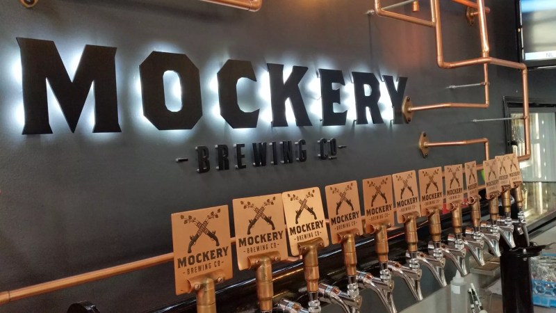 wooden beer taps against a grey wall