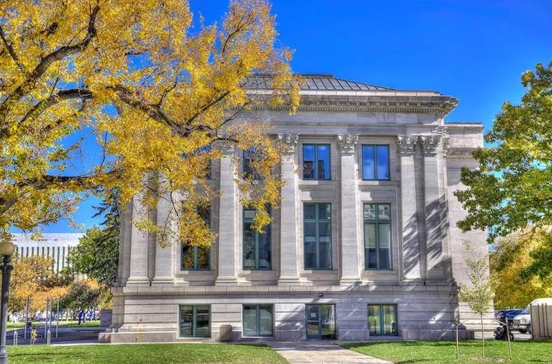A white stone building with columns and tall windows.