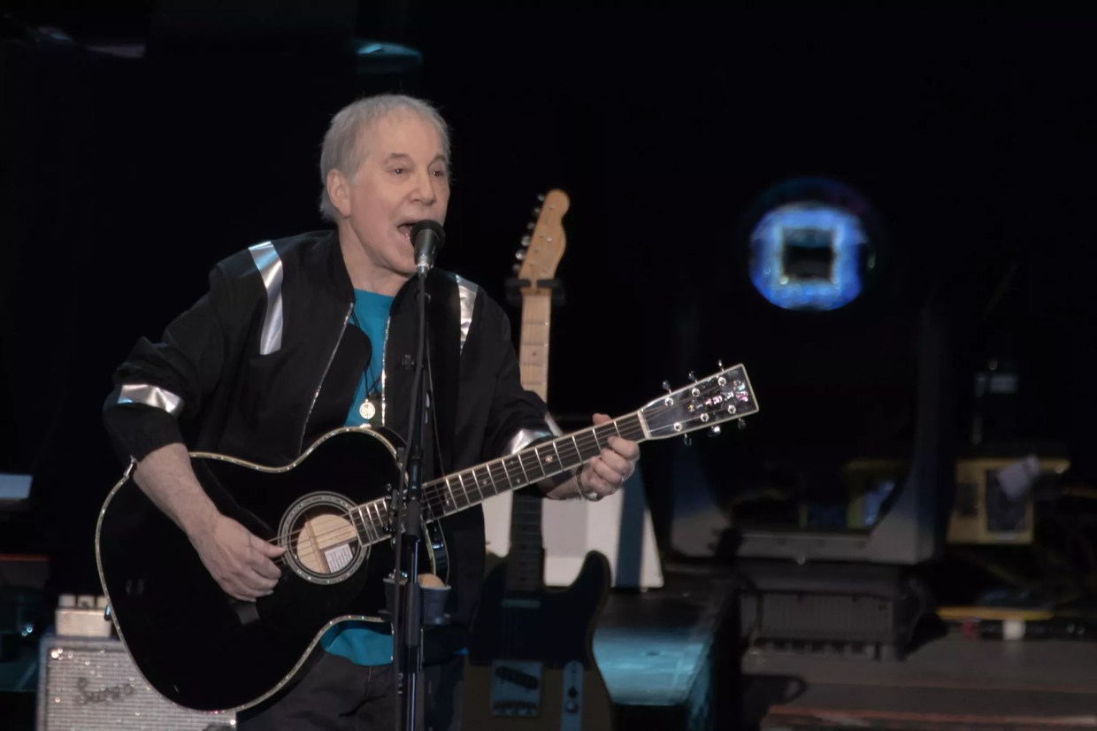 paul simon playing guitar on stage