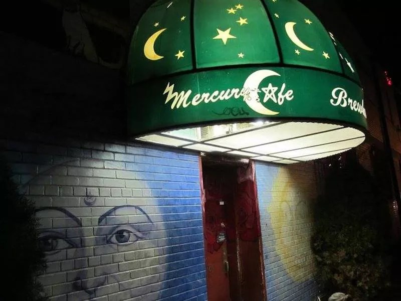 cafe with green banner and moon and sun murals