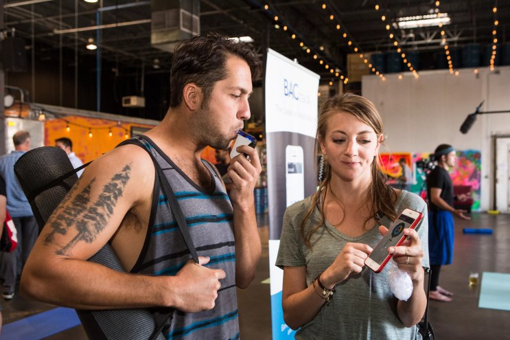 A man tests out a breathalyzer at a CDOT event