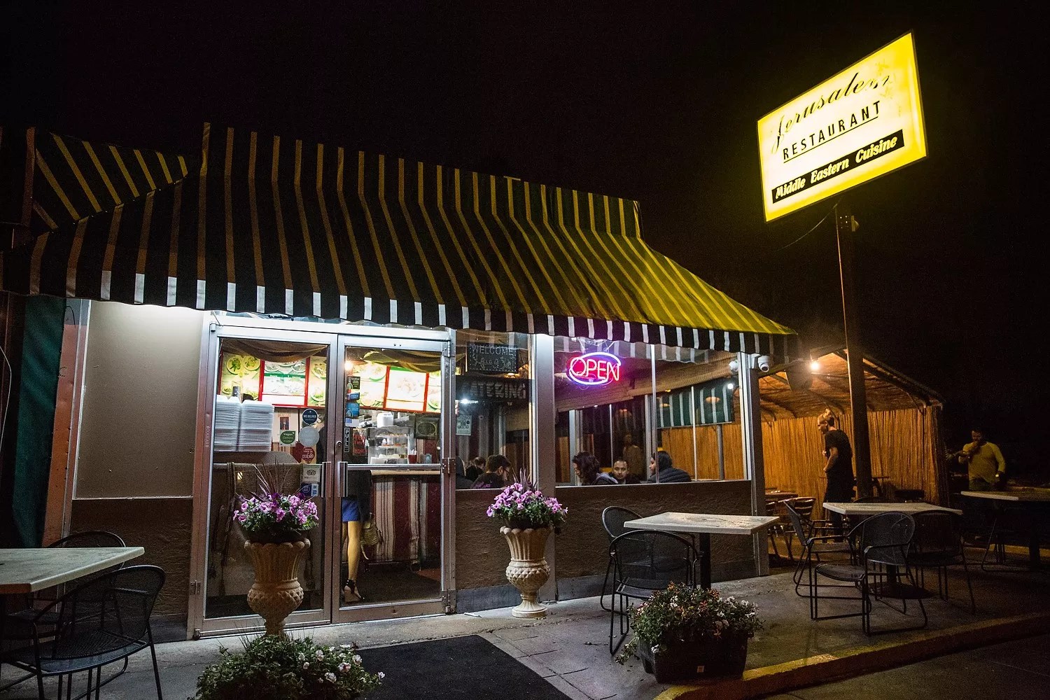 the outside of a restaurant with a yellow, lit up sign