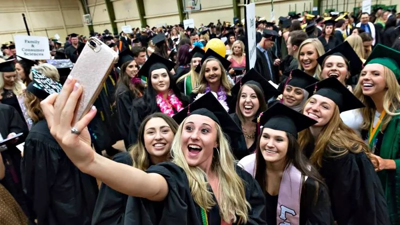 Colorado State University graduates take a photo in their caps