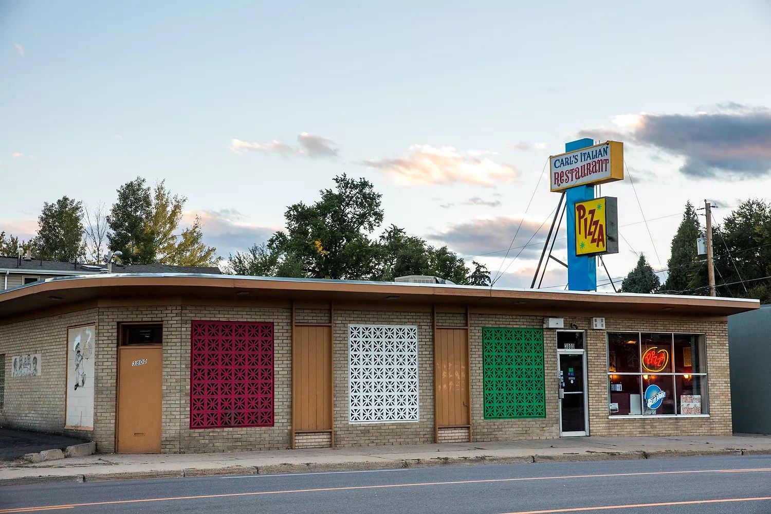 exterior of a building with a "carl's pizza" sign