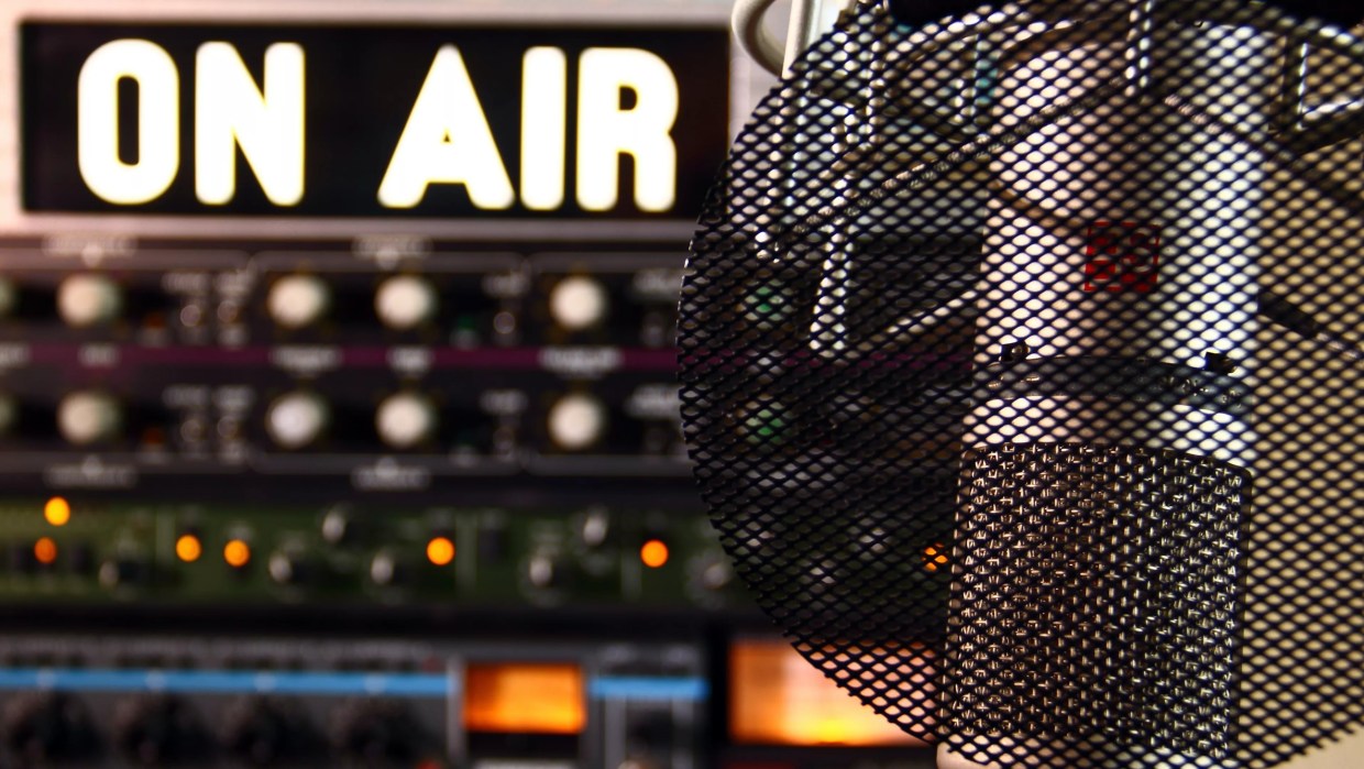a radio microphone in front of an on air sign