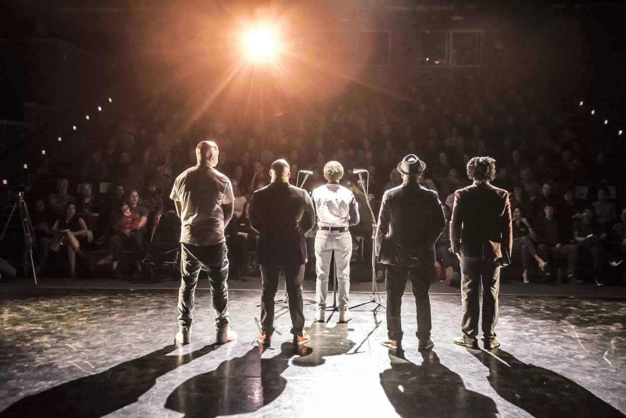 A stage of people with their backs turned