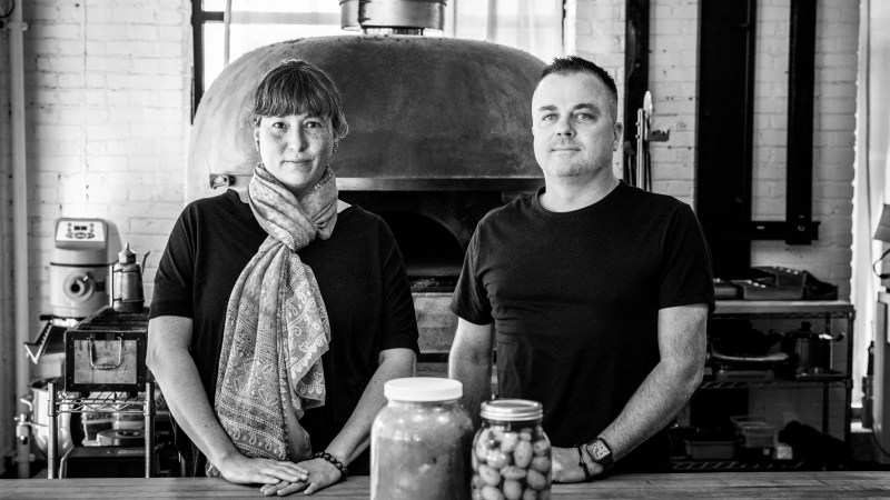 black and white photo of a woman in a scarf next to a man in a black t shirt