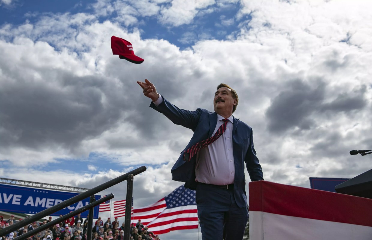 Mike Lindell of MyPillow tosses a MAGA hat into the air