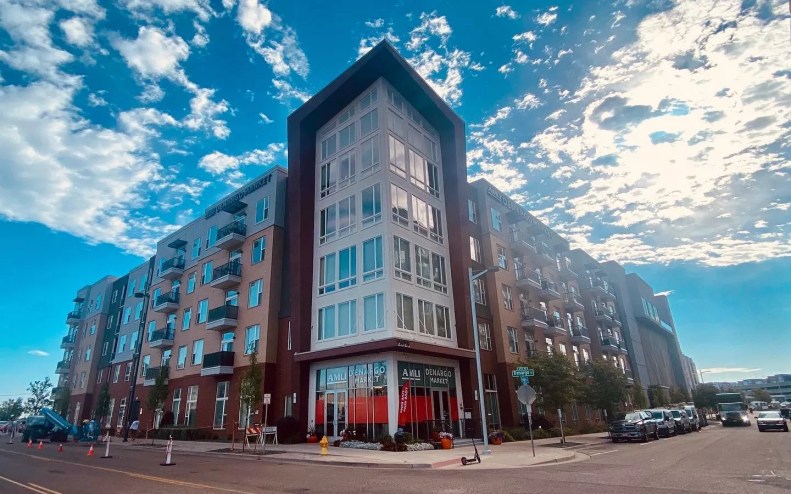 A building covered in windows on the corner of a street.