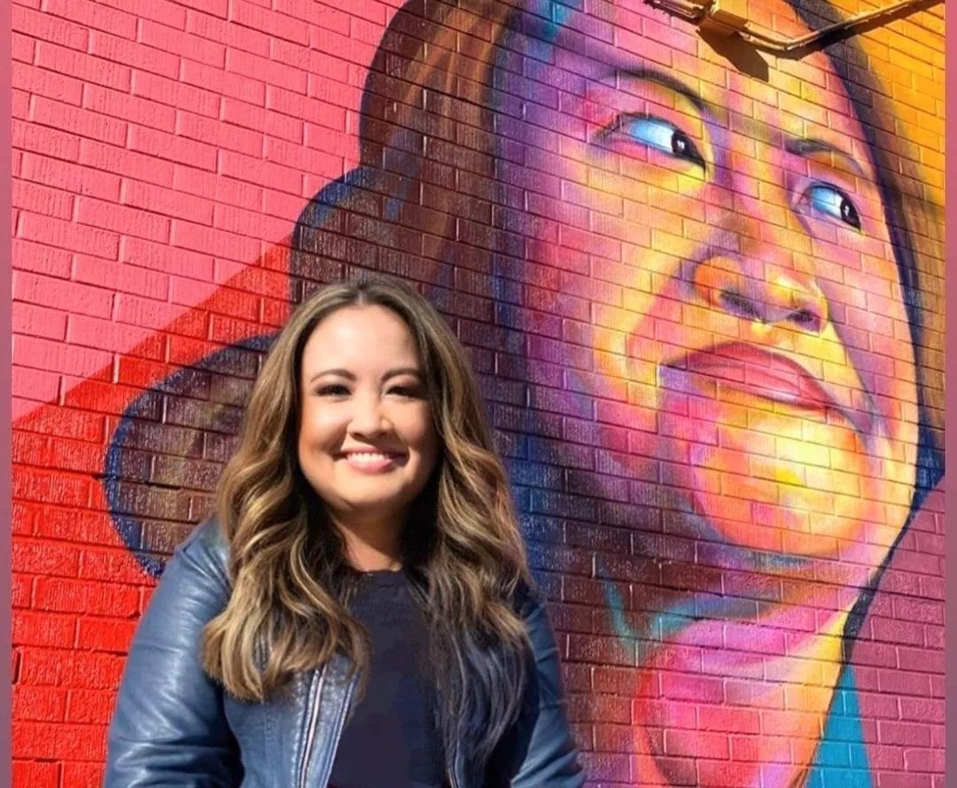 woman in front of mural portrait