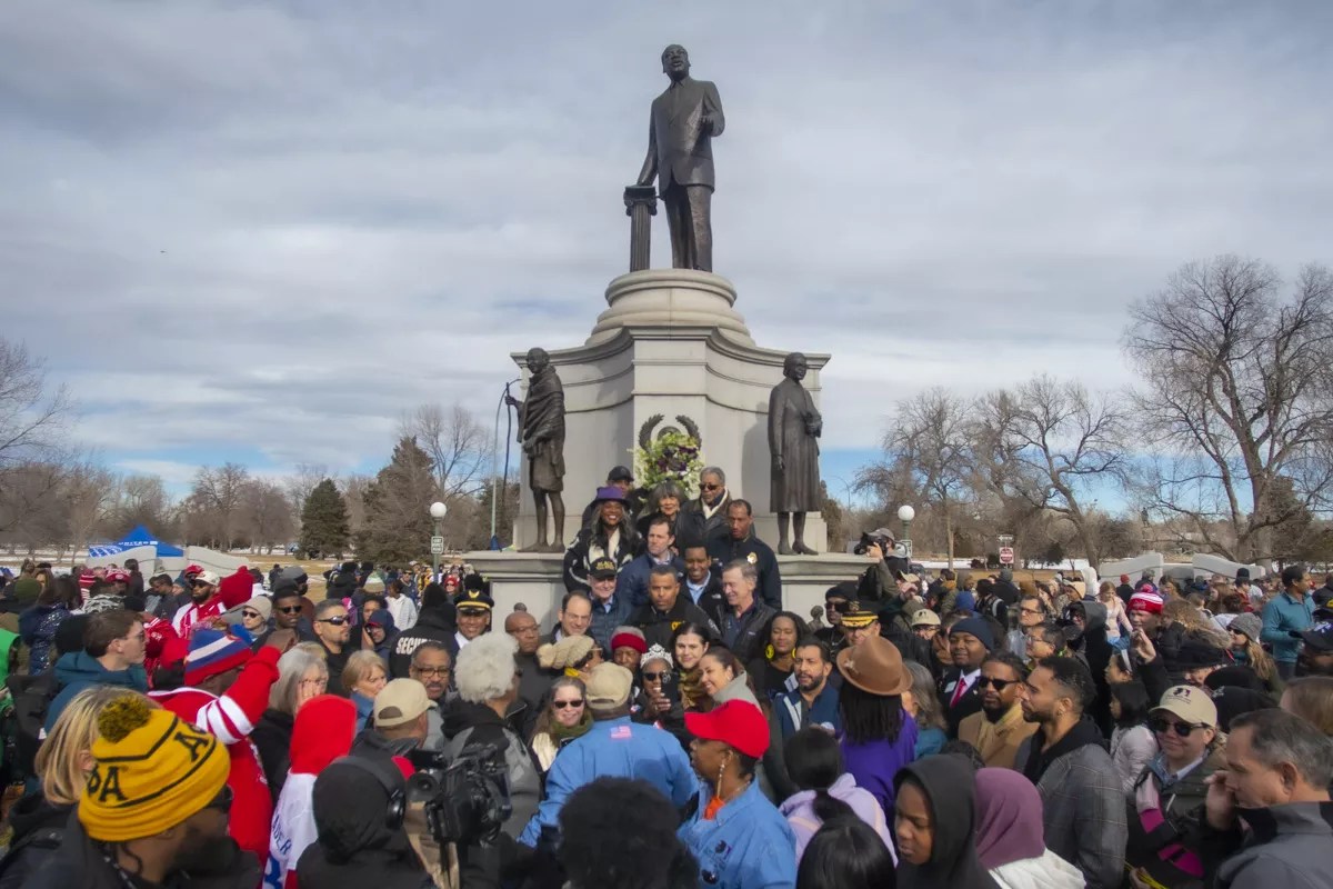 people gather around the MLK sculpture in Denver's City Park