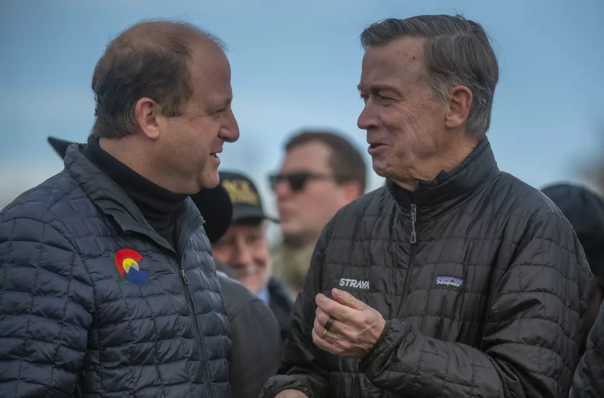 Colorado Governor Jared Polis talks with U.S. Senator John Hickenlooper