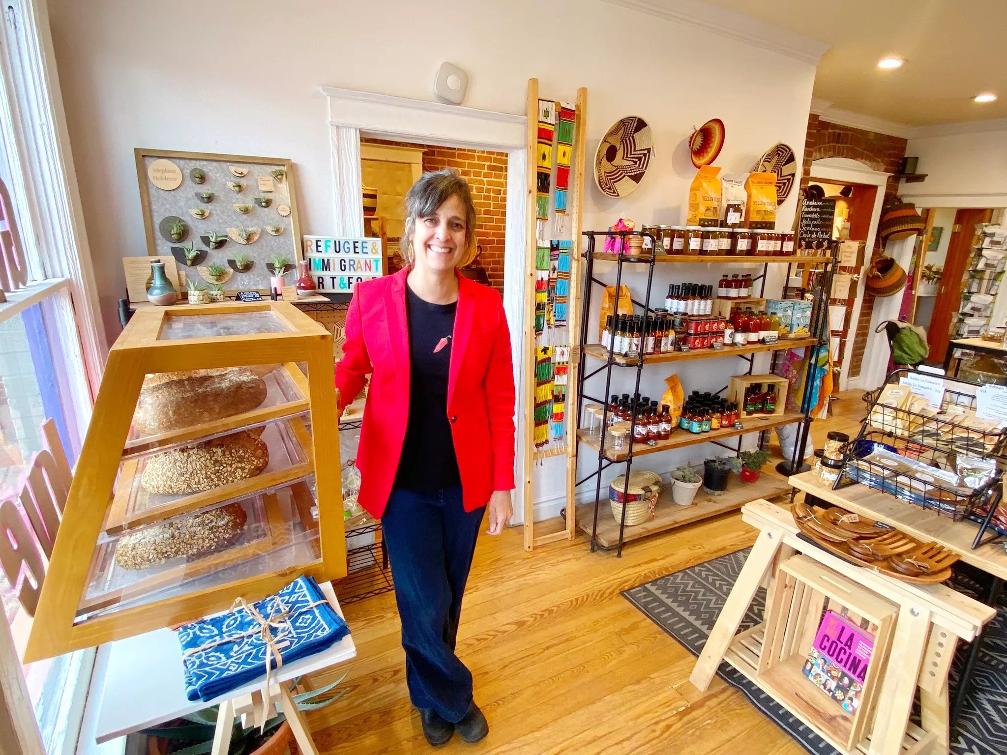 a woman in a red blazer standing in a shop