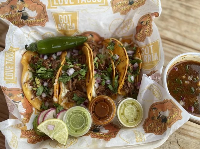 tacos in a box topped with onions and cilantro