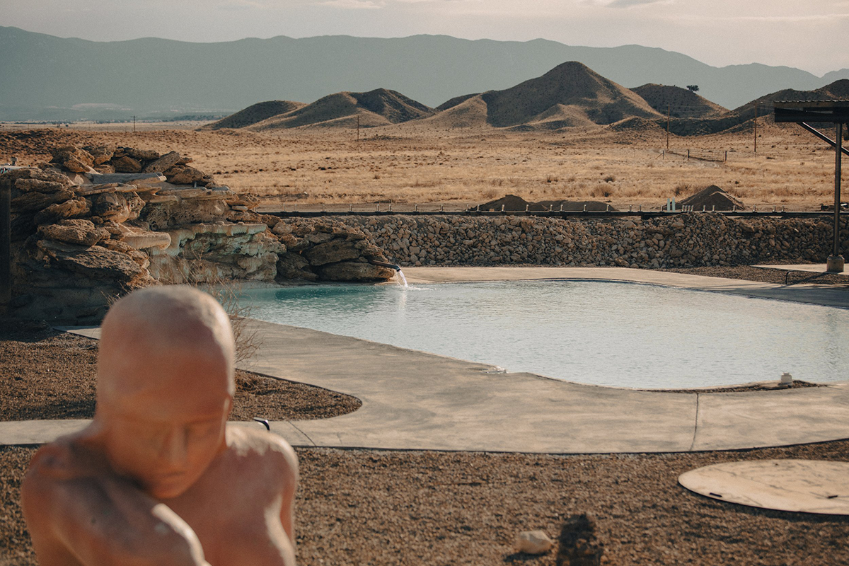 A landscape of mountains and a hot spring at Desert Reef Hot Springs in Florence Colorado.