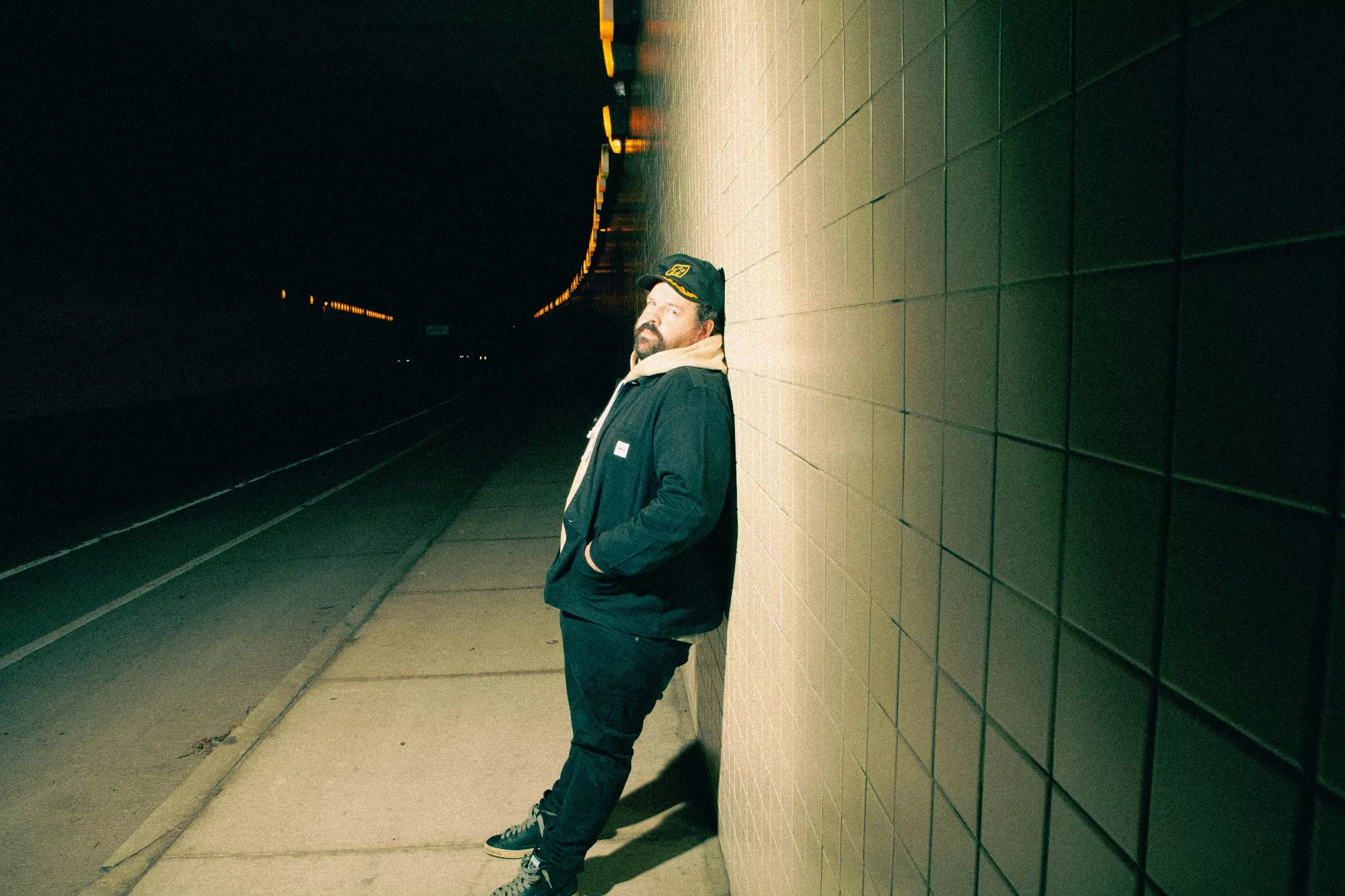 man leaning against concrete wall