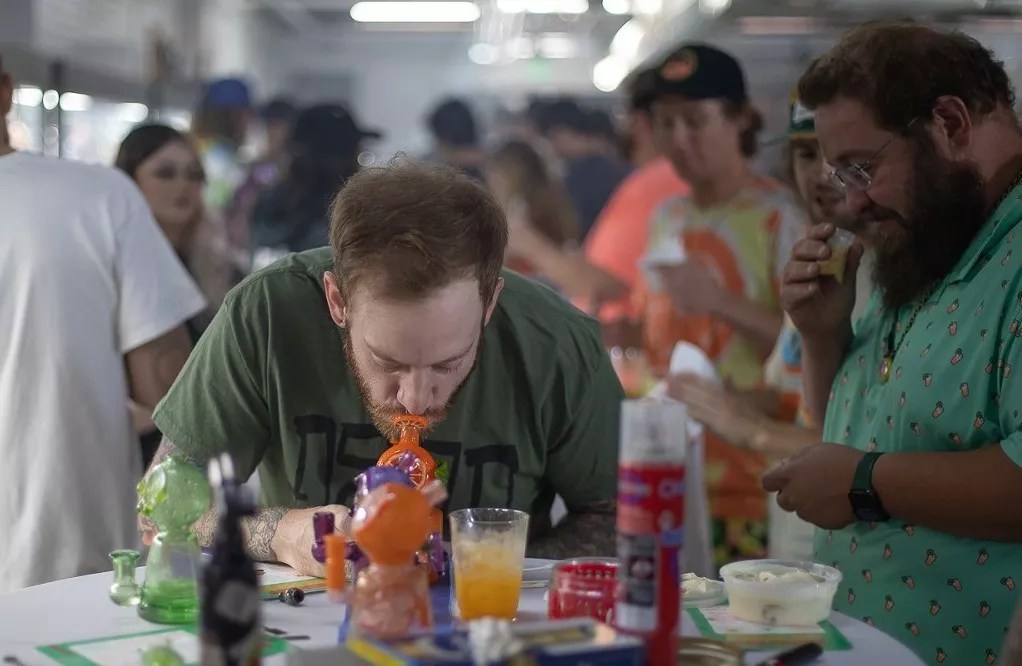 A man takes a dab of hash rosin at a Groovy Gravy event in Denver.