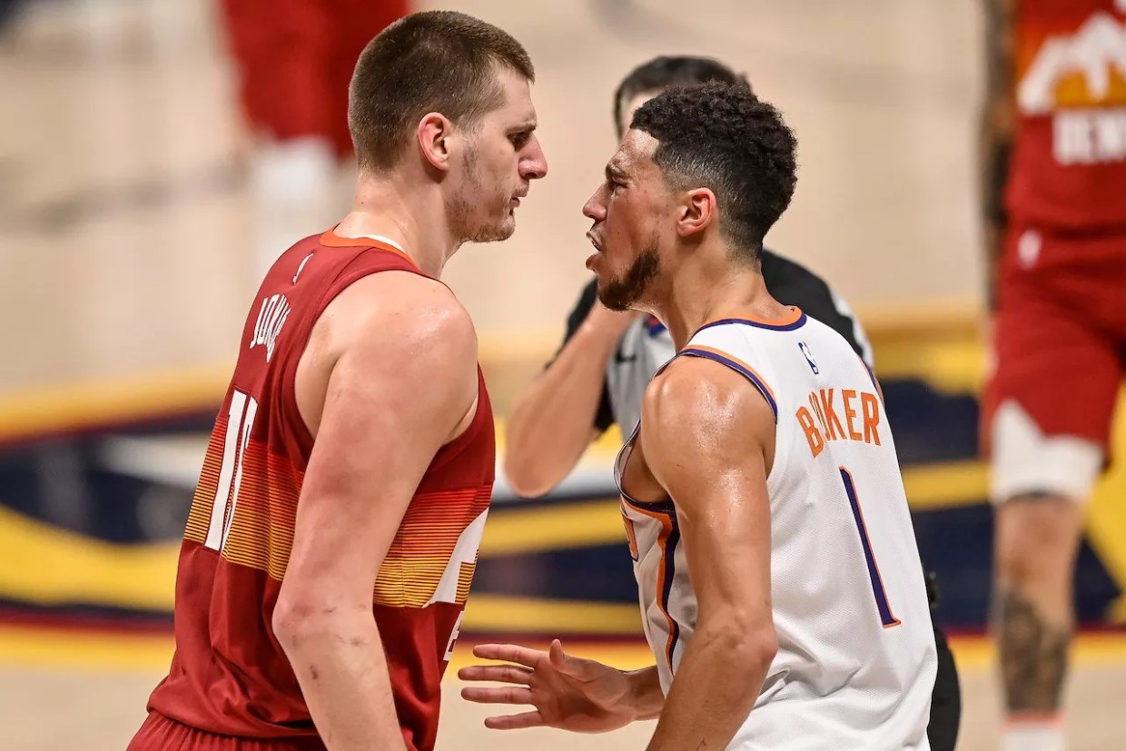 Nikola Jokic of the Denver Nuggets and Devin Booker of the Phoenix Suns tangle in Game Four of the Western Conference second-round playoff series at Ball Arena in 2021