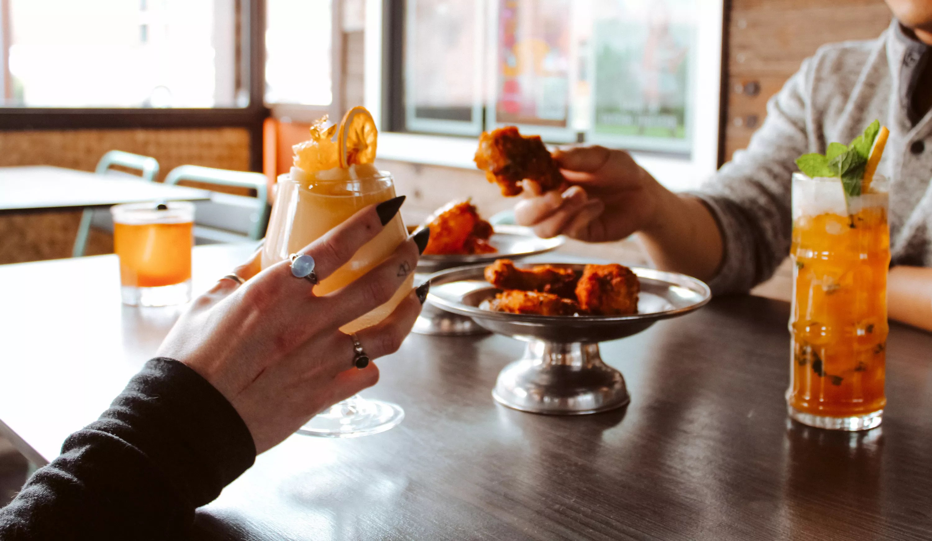 hands holding chicken wings