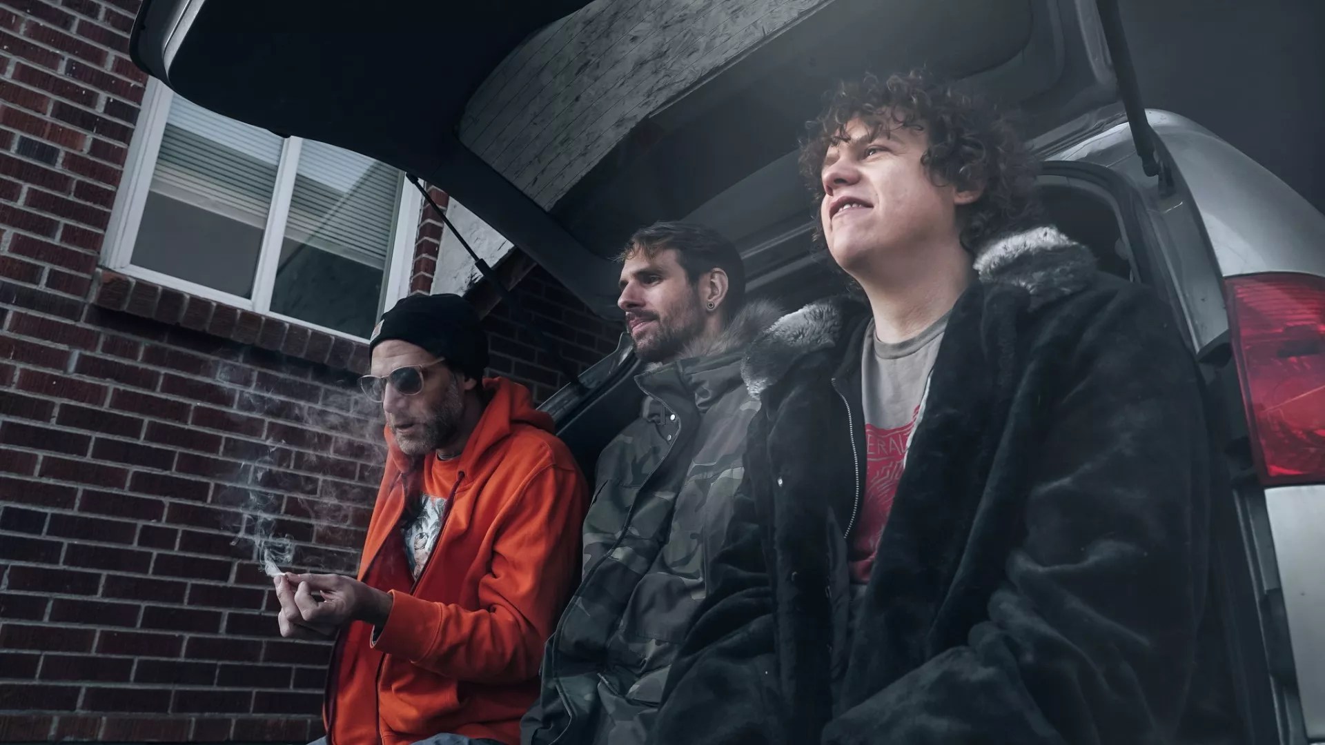 three men smoking a joint