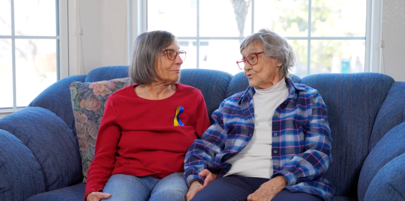 two elderly women speak with each other