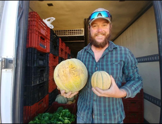 a man holding two melons