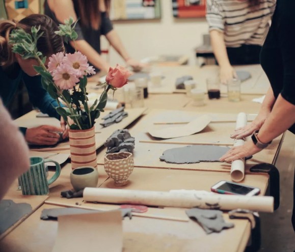 people roll out clay in a craftroom