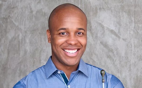 smiling man in a blue collared shirt
