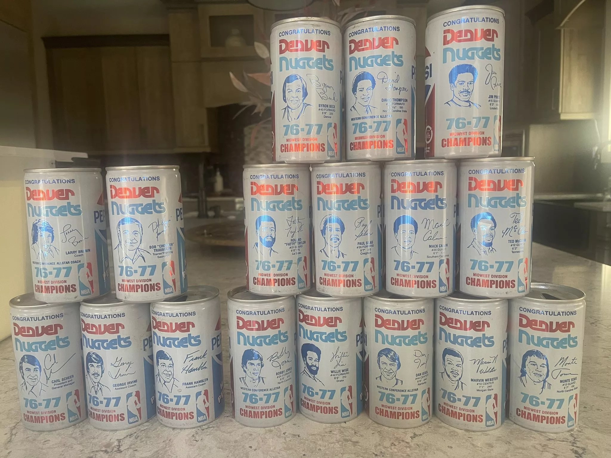 Seventeen white pepsi cans depicting basketball players outlined in blue.