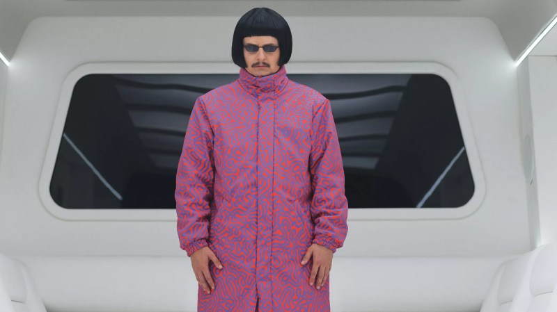 musician with bowl cut in a pink jacket