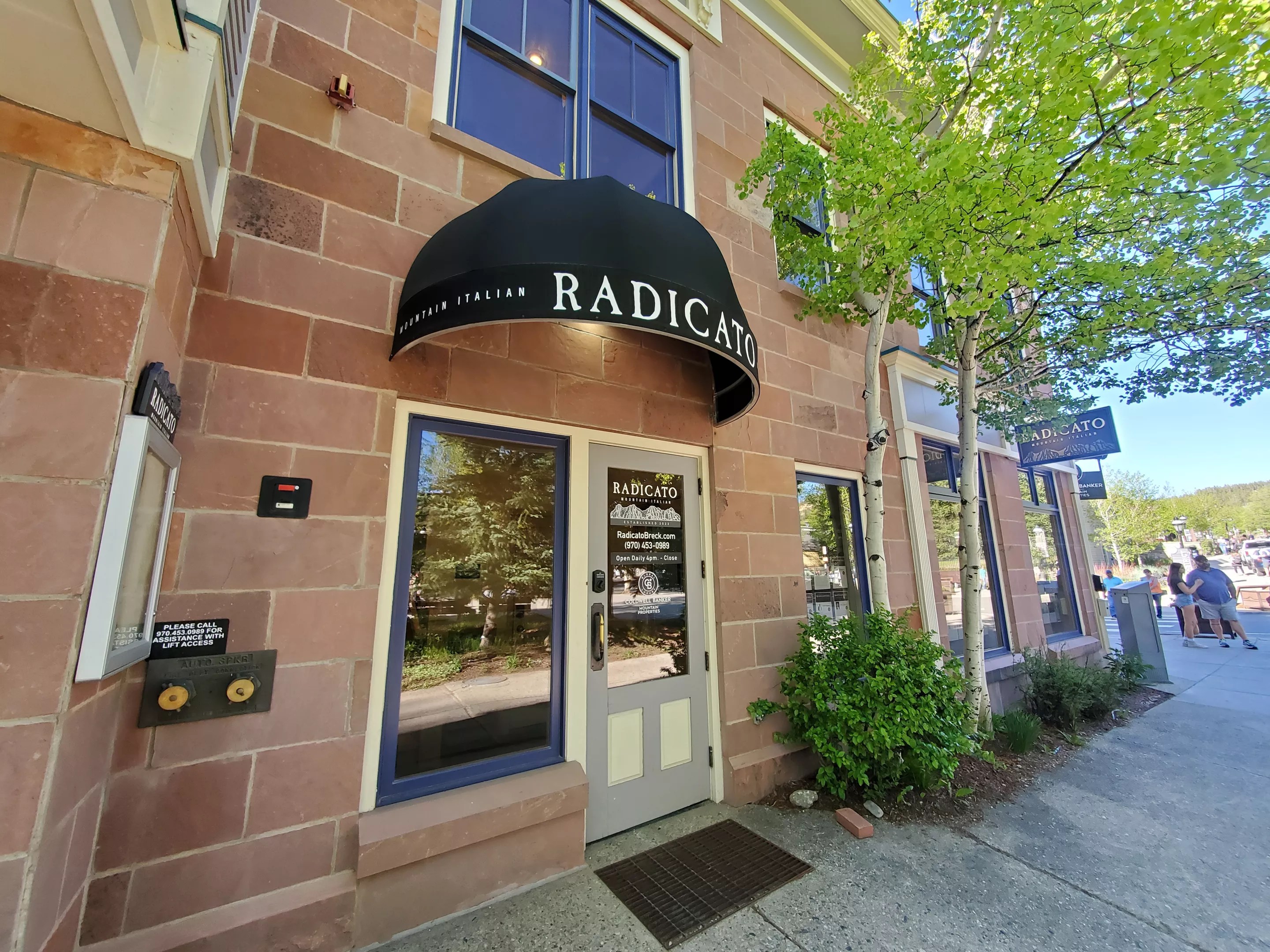 a brick building with a black awning over the doorway