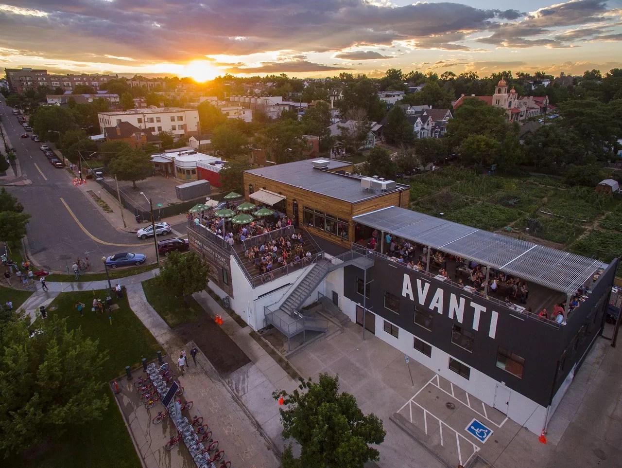 an overhead shot of a building with a rooftop patio during sunset