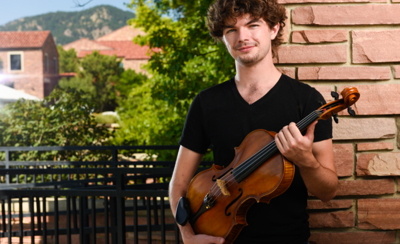 Composer Jordan Holloway poses with his viola.