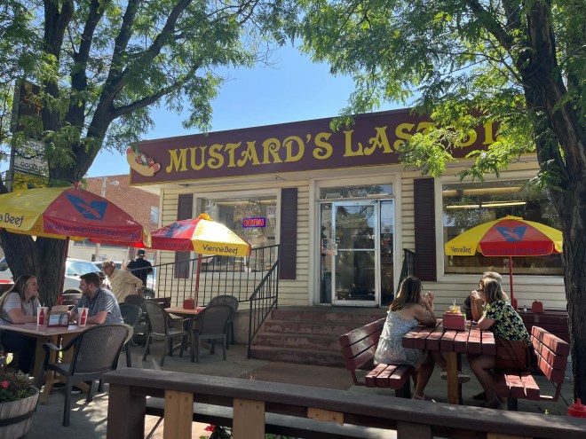 tables with umbrellas in front of a restaurant